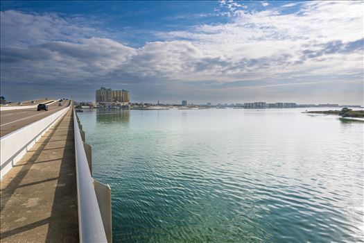 vehicle bridge with walking path blue sky blue water no people cars and trucks at destin harbor