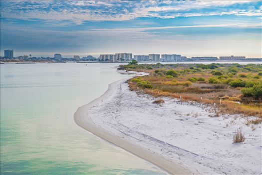 Destin Harbor Florida USA shines under a brilliant blue sky, with fluffy clouds reflecting on the emerald-green waters, creating a picture-perfect coastal scene.