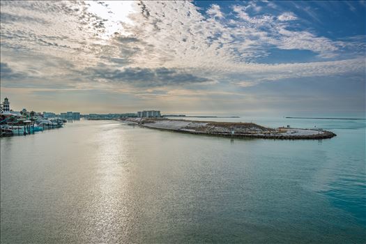 Destin Harbor Florida USA shines under a brilliant blue sky, with fluffy clouds reflecting on the emerald-green waters, creating a picture-perfect coastal scene.