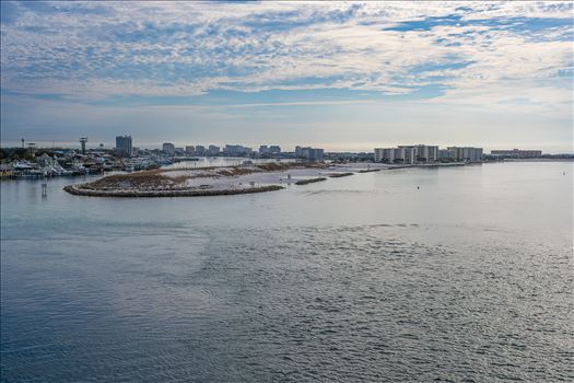 Destin Harbor Florida USA shines under a brilliant blue sky, with fluffy clouds reflecting on the emerald-green waters, creating a picture-perfect coastal scene.